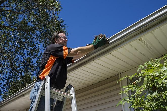 a technician repairing a rusted gutter on a house in Campbelltown, PA